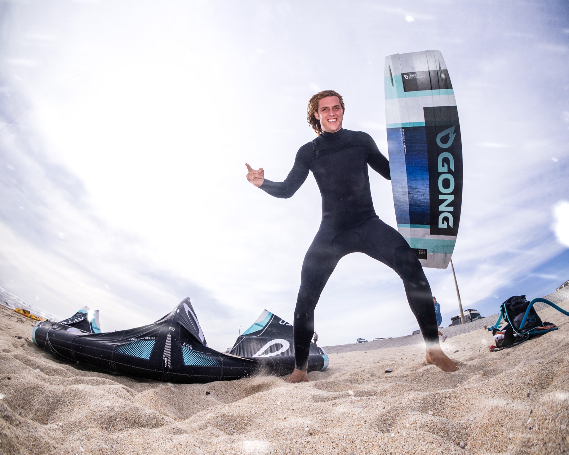 Yücel Paralik on the sand with his GONG board and kites rigged
