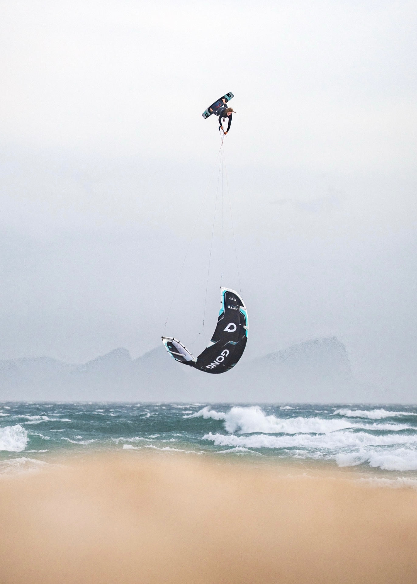 Yücel Paralik launched high above the beach by a GONG kite during a big air session